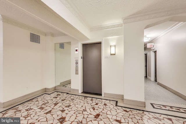 unfurnished room with elevator, crown molding, a textured ceiling, and baseboards