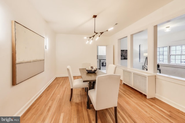 dining area with light wood-style floors, baseboards, and a chandelier