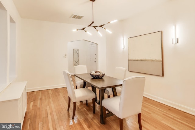 dining space featuring visible vents, light wood-style flooring, and baseboards