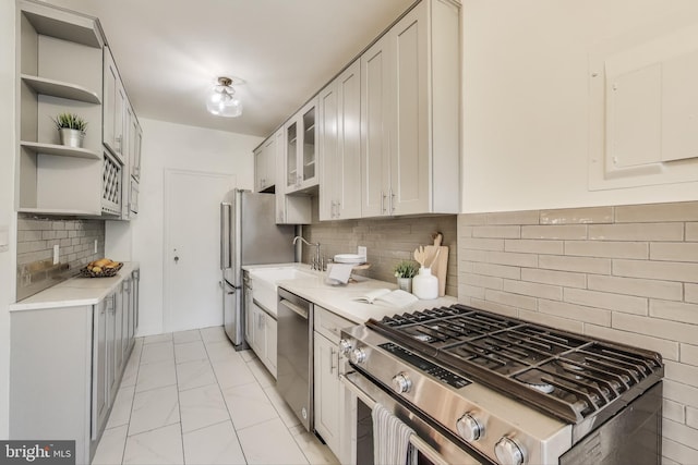 kitchen with open shelves, light countertops, appliances with stainless steel finishes, glass insert cabinets, and white cabinetry