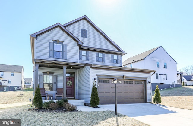 traditional home with concrete driveway, covered porch, and an attached garage