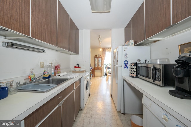 kitchen featuring light countertops, stainless steel microwave, a sink, and light floors