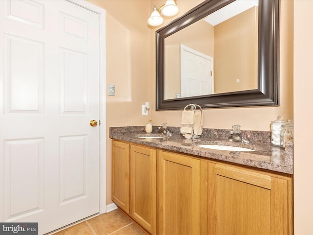 full bath featuring double vanity, tile patterned floors, and a sink