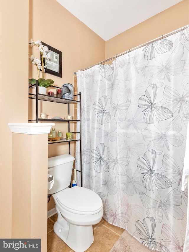 full bathroom featuring curtained shower, toilet, and tile patterned flooring