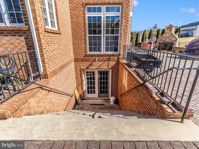 view of exterior entry featuring brick siding