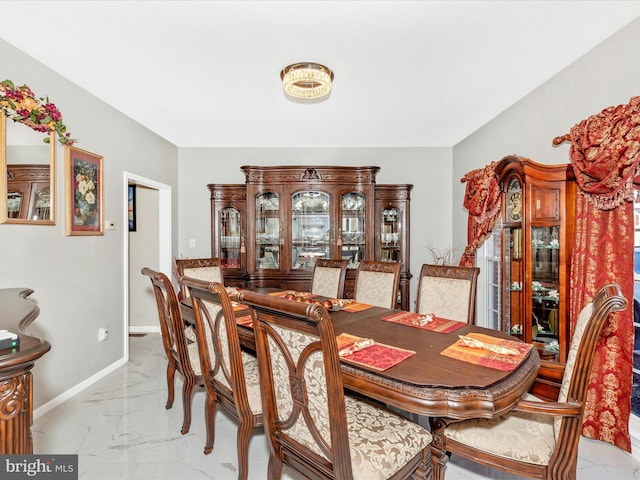 dining space with baseboards and marble finish floor