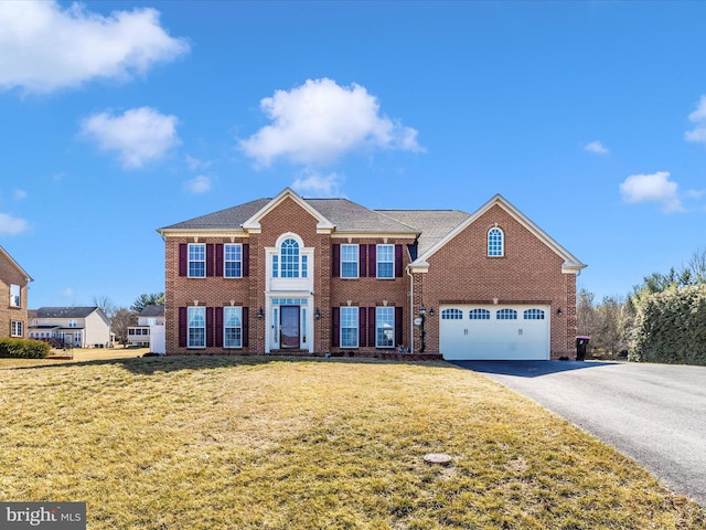 view of front of home featuring aphalt driveway, a garage, brick siding, and a front lawn