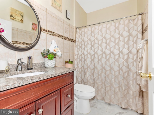 full bathroom with toilet, marble finish floor, curtained shower, tile walls, and vanity