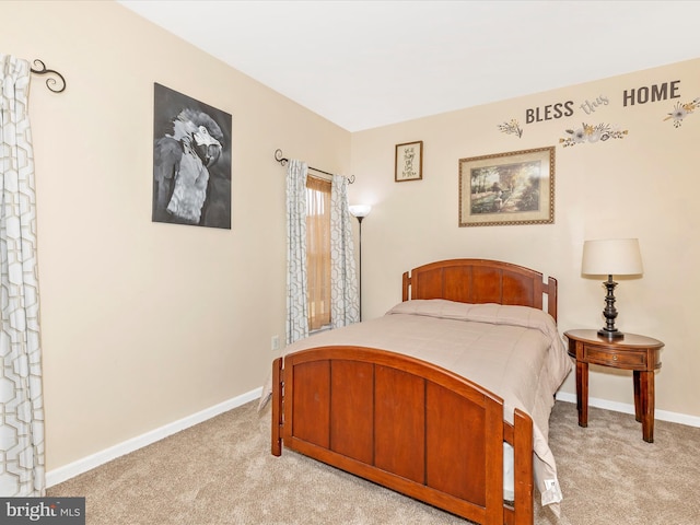 bedroom with light carpet and baseboards