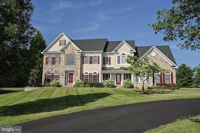 view of front of house with stone siding and a front yard