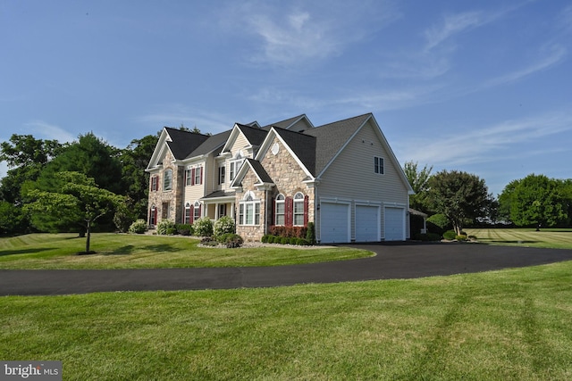 view of front facade featuring stone siding, driveway, an attached garage, and a front yard