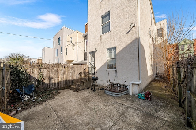 exterior space featuring a patio area, a fenced backyard, and stucco siding