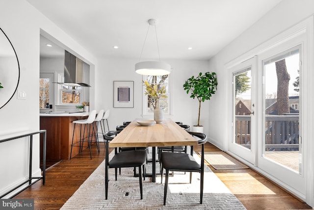 dining space featuring baseboards, wood finished floors, and recessed lighting