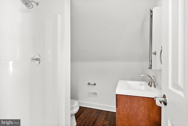 bathroom featuring visible vents, a shower, toilet, wood finished floors, and vanity