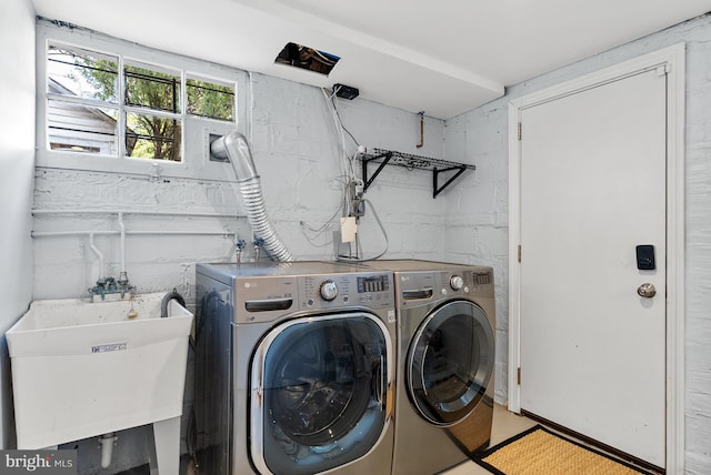 laundry room featuring laundry area, washer and clothes dryer, and a sink