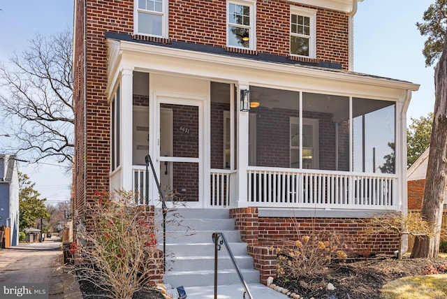 view of exterior entry featuring brick siding