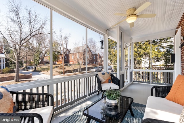 sunroom with a residential view, plenty of natural light, and ceiling fan