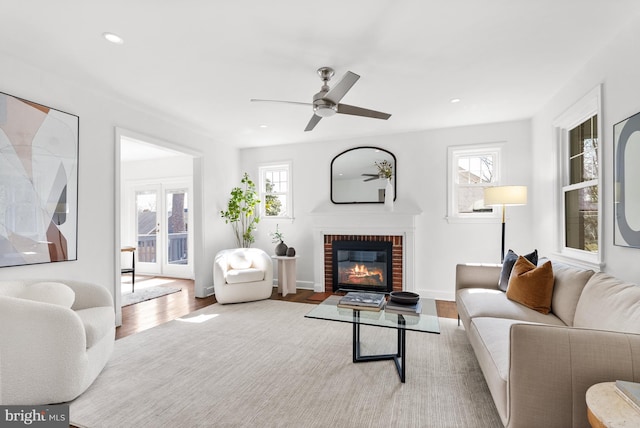 living area with recessed lighting, a brick fireplace, wood finished floors, and a healthy amount of sunlight