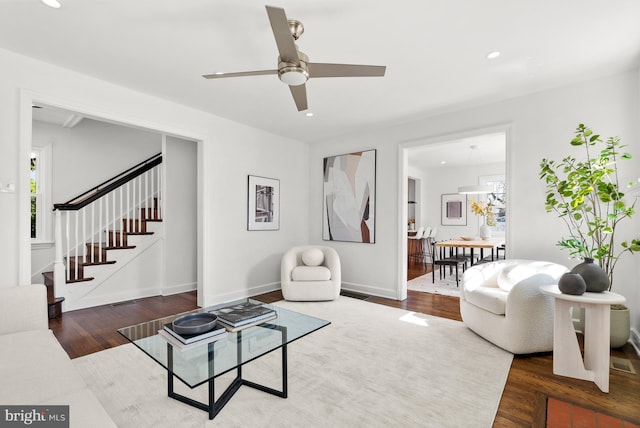 living room featuring baseboards, ceiling fan, wood finished floors, stairs, and recessed lighting