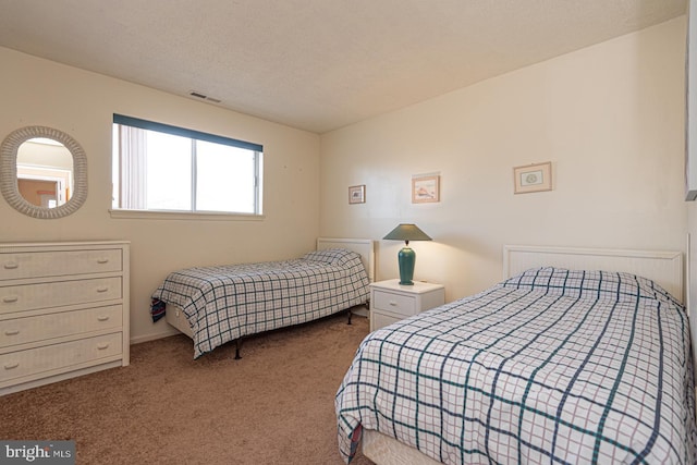 bedroom with carpet flooring, visible vents, and a textured ceiling