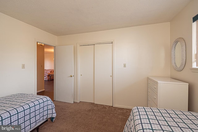 bedroom with a textured ceiling, a closet, and carpet flooring