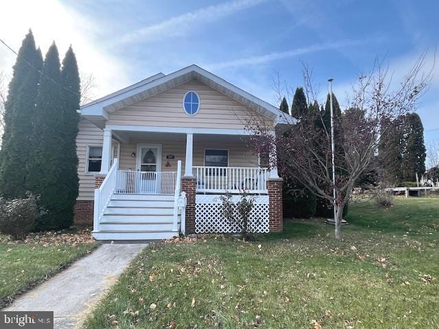 bungalow with a front yard and covered porch