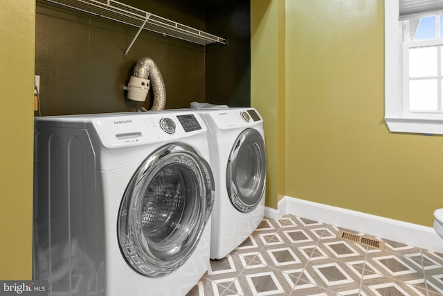 washroom with laundry area, independent washer and dryer, visible vents, and baseboards