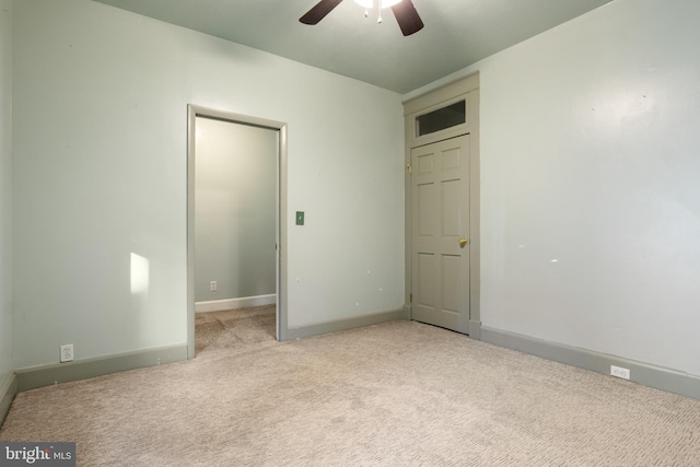 unfurnished bedroom with carpet, a ceiling fan, and baseboards