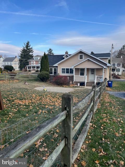 bungalow featuring a fenced front yard and a porch