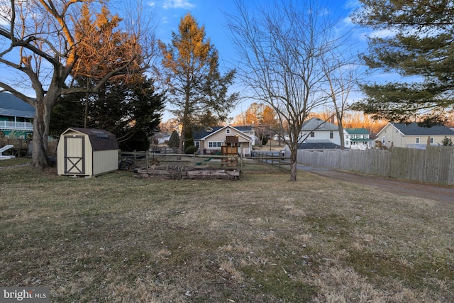 view of yard with an outbuilding, a shed, and fence