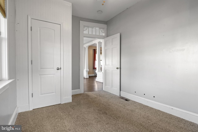 unfurnished bedroom featuring carpet flooring, visible vents, and baseboards