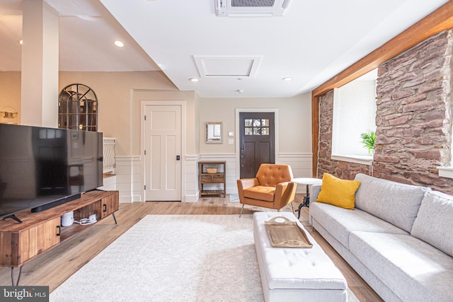 living room with attic access, visible vents, a wainscoted wall, light wood-style flooring, and recessed lighting