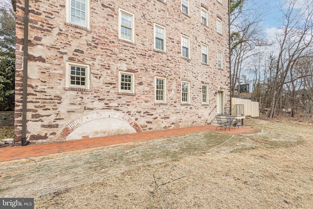 view of property exterior with a patio area and a lawn