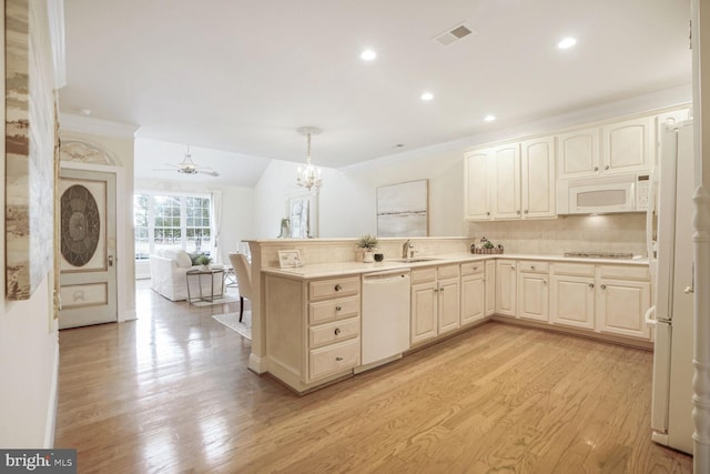 kitchen featuring white appliances, visible vents, a peninsula, light wood-style floors, and a sink