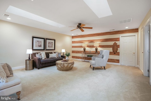 carpeted living room featuring a ceiling fan, a skylight, visible vents, and recessed lighting