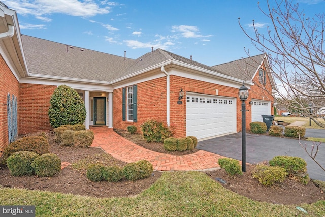 view of front of property featuring aphalt driveway, brick siding, a shingled roof, and a garage