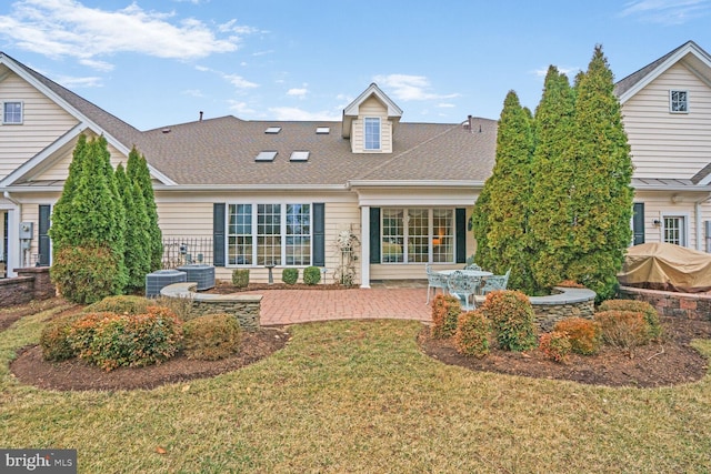 back of house featuring a shingled roof, a lawn, a patio area, and central air condition unit