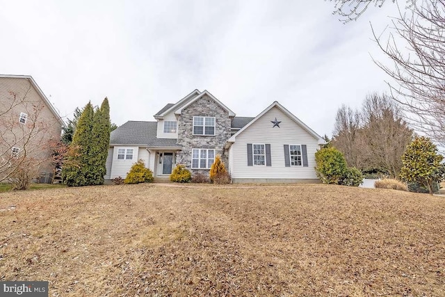 traditional home featuring stone siding and a front lawn