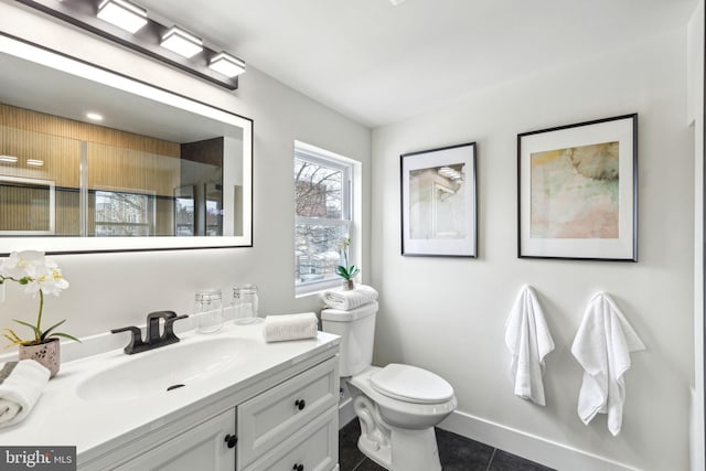 bathroom with toilet, tile patterned flooring, vanity, and baseboards