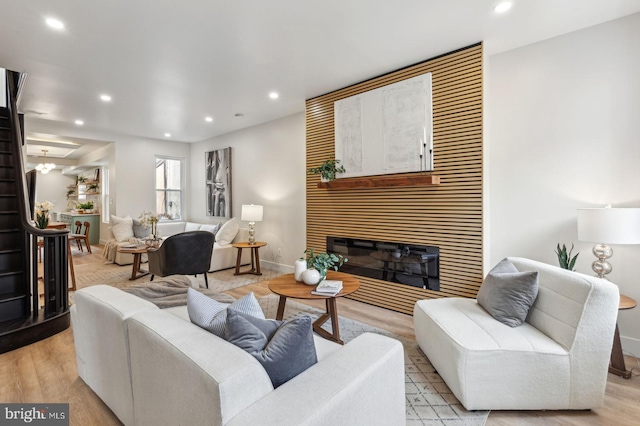 living area featuring light wood-style floors, recessed lighting, and a large fireplace