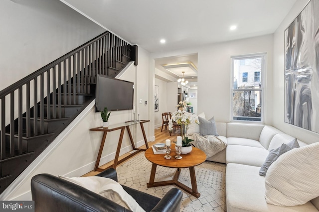 living area featuring baseboards, an inviting chandelier, stairs, light wood-type flooring, and recessed lighting