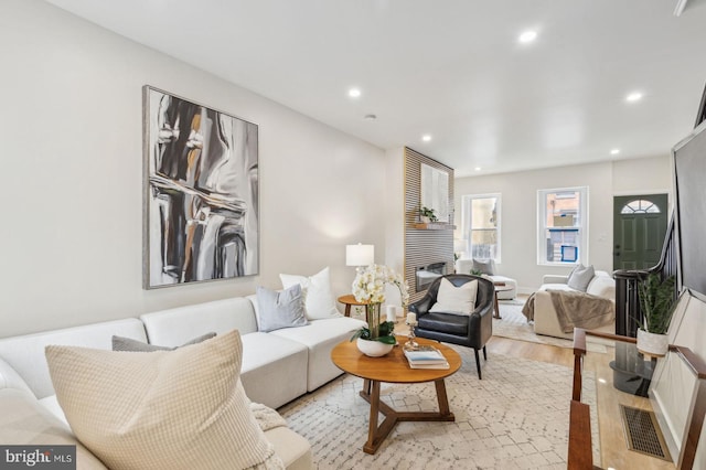 living room with light wood-type flooring and recessed lighting