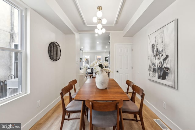 dining space with light wood finished floors, visible vents, and baseboards