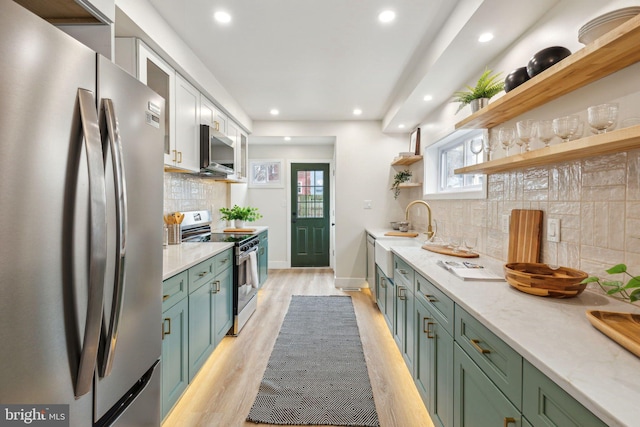 kitchen featuring appliances with stainless steel finishes, light stone counters, light wood-type flooring, white cabinetry, and open shelves