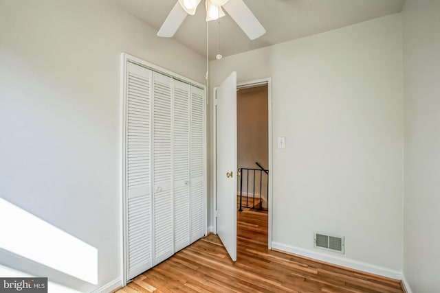 unfurnished bedroom with baseboards, visible vents, a ceiling fan, light wood-type flooring, and a closet