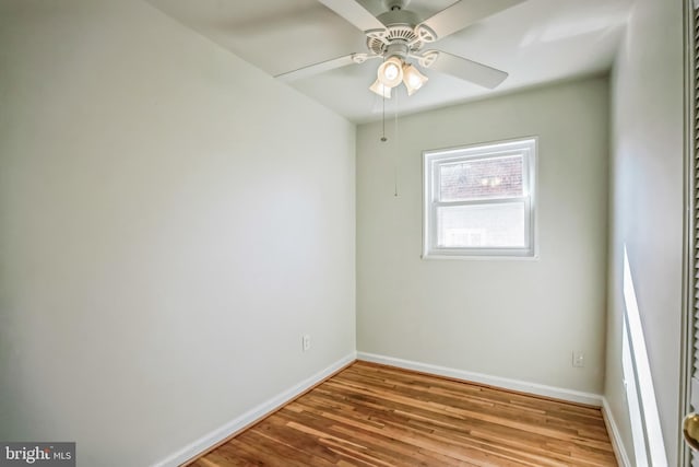 spare room with a ceiling fan, baseboards, and wood finished floors