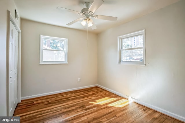 unfurnished bedroom with multiple windows, a closet, and wood finished floors