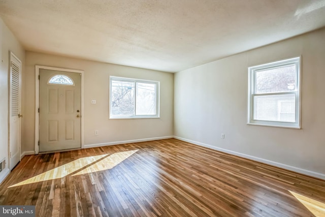 foyer entrance with baseboards and hardwood / wood-style flooring