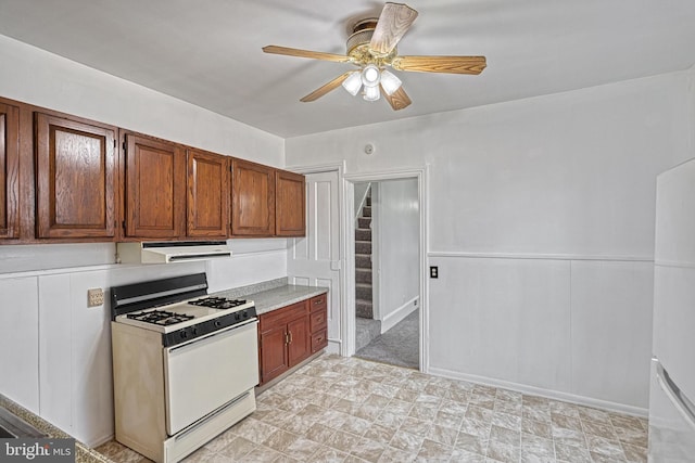 kitchen with ceiling fan, light countertops, exhaust hood, and white range with gas cooktop