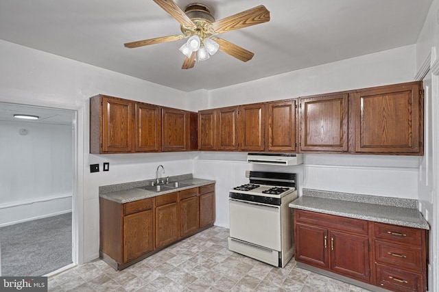 kitchen with gas range gas stove, a sink, a ceiling fan, and range hood